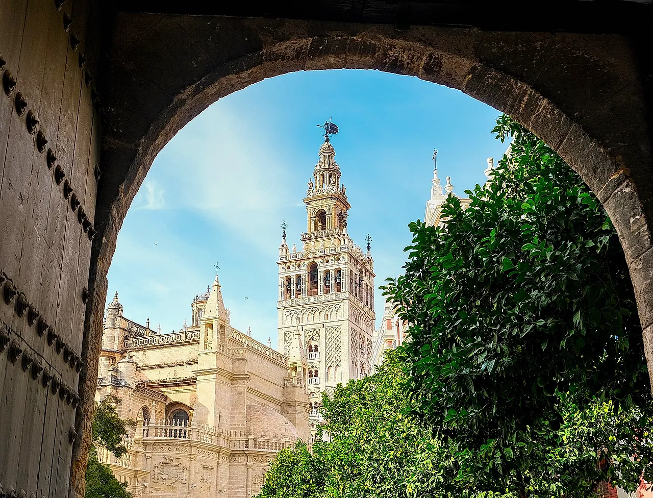 The Giralda framed by an arch, with the cathedral beside it
