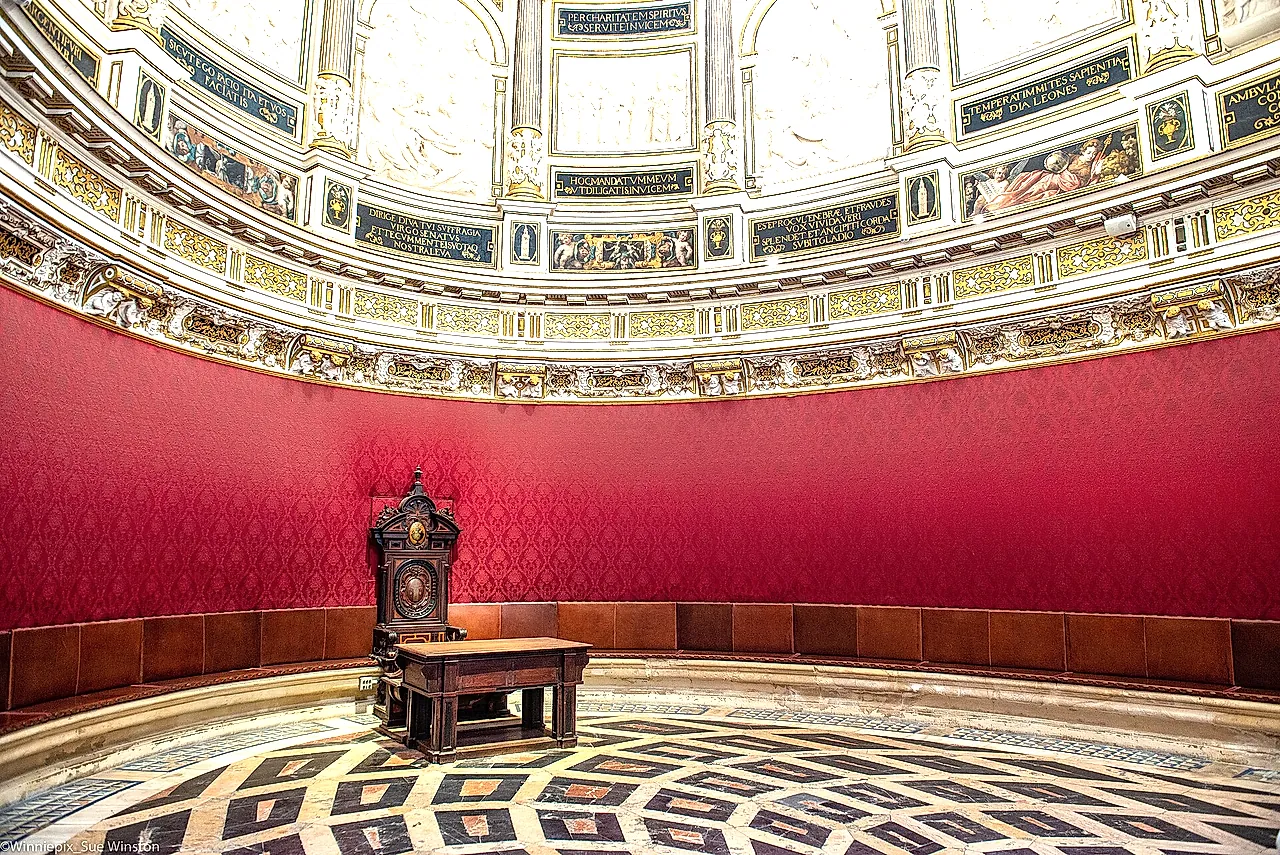 The elliptical Chapter House with red hangings and a marble floor