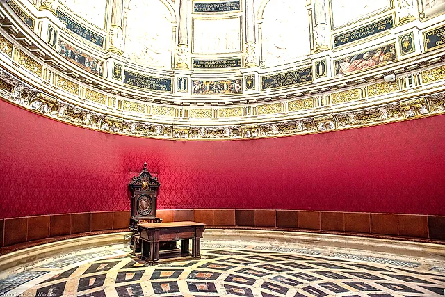 The elliptical Chapter House with red hangings and a marble floor