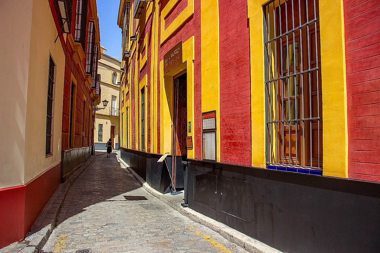A narrow street in the Santa Cruz quarter with yellow and red walls