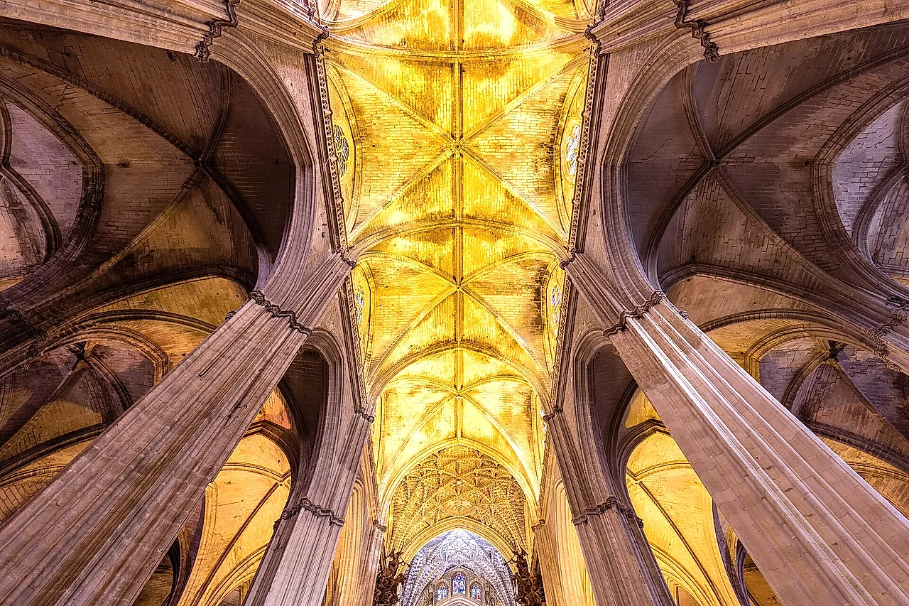Ribbed Gothic vaults lit in gold inside the cathedral